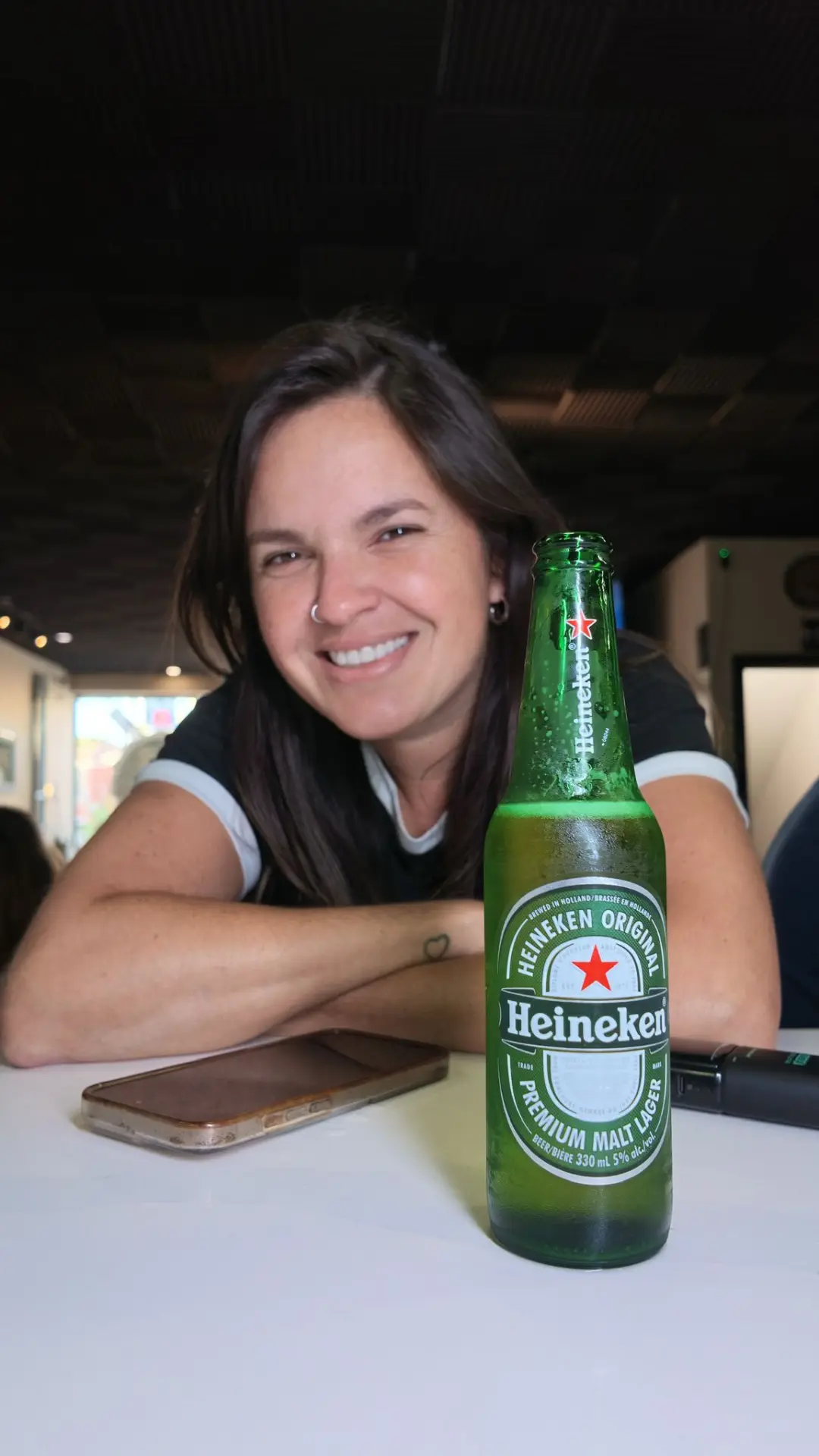 Guest smiling behind a cold Heineken at the table