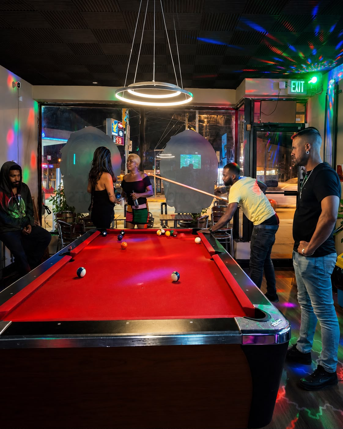 Guests playing pool under colourful lights at Roots Bar